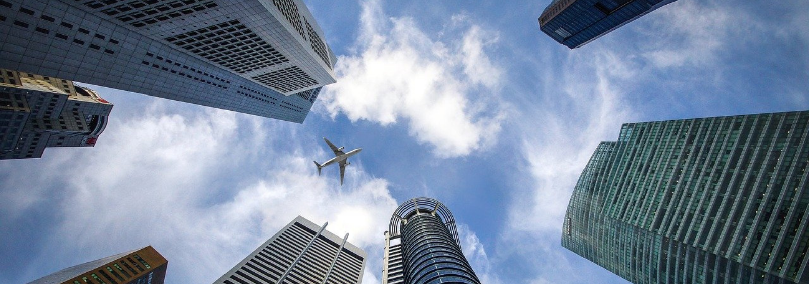 Vista de baixo para cima com prédios e avião